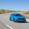 A Boost Blue Honda Civic Type R driving on a track