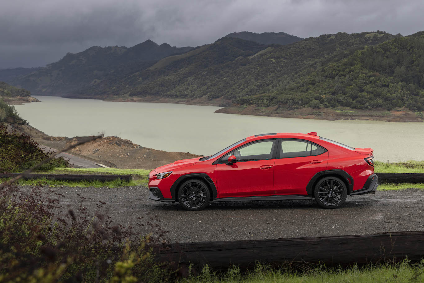 A red 2022 Subaru WRX parked in front of a lake. The Subaru WRX price is higher than it should be to be competitive in sales.
