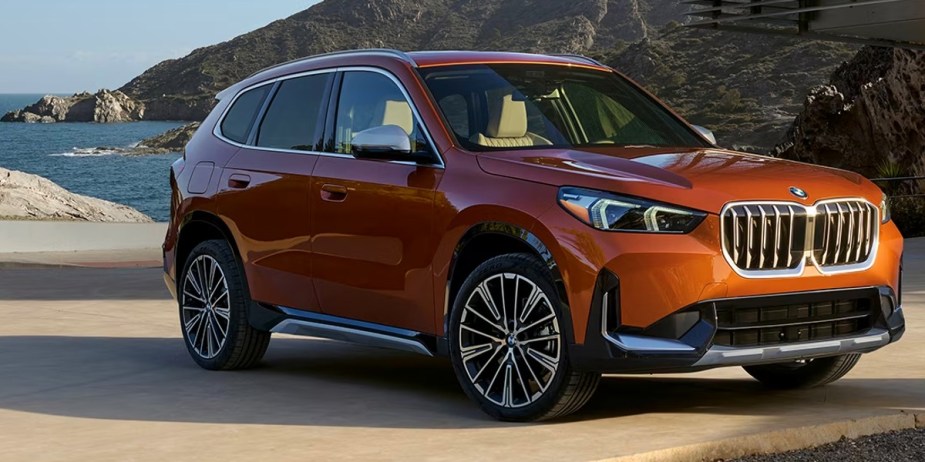 An orange 2023 BMW X1 luxury subcompact SUV is parked. 