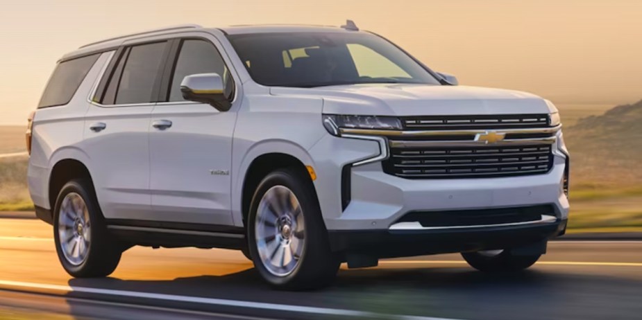 A white 2023 Chevrolet Tahoe full-size SUV is driving on the road. 