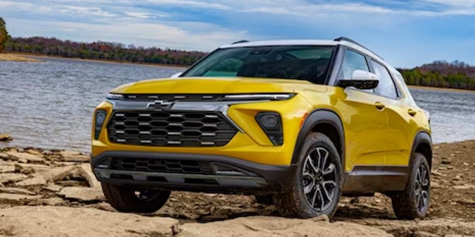 A yellow 2023 Chevrolet Trailblazer subcompact SUV is driving off-road. 