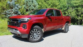 The red 2023 Chevy Colorado parked near green foliage