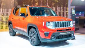 An orange Jeep Renegade on display at an auto show.