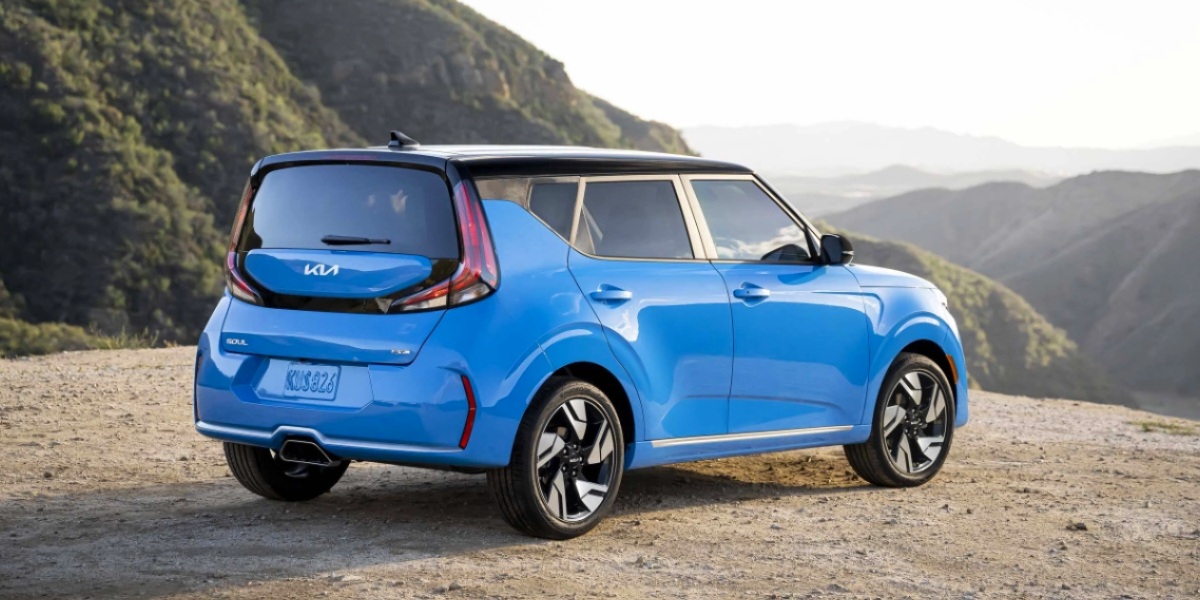 A blue 2023 Kia Soul subcompact SUV is parked off-road.