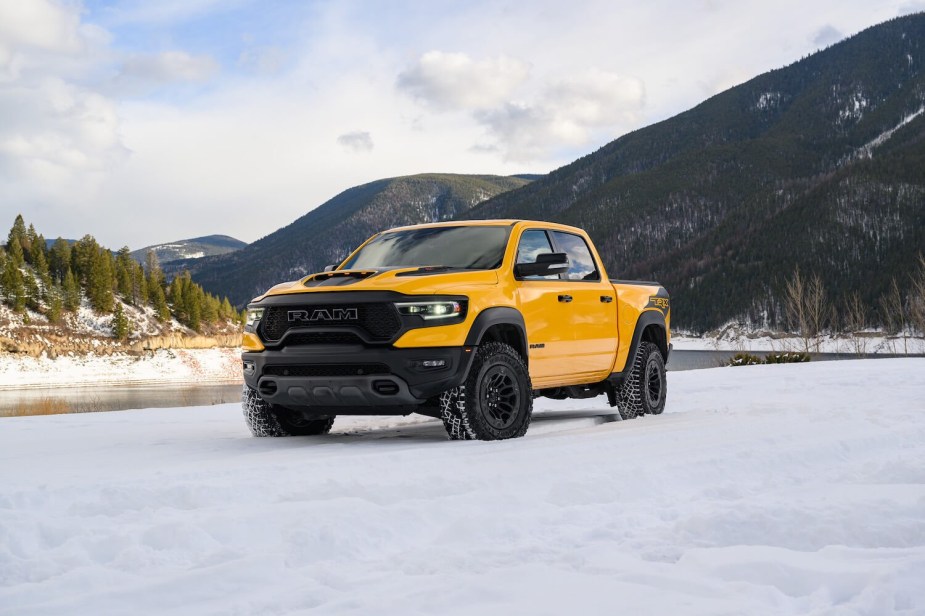 Bright yellow Ram 1500 TRX off-road supertruck parked in the snow, mountains visible in the background.