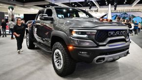A woman cleans the side of the 2023 Ram 1500 TRX trim level on display at the 2022 Los Angeles Auto Show
