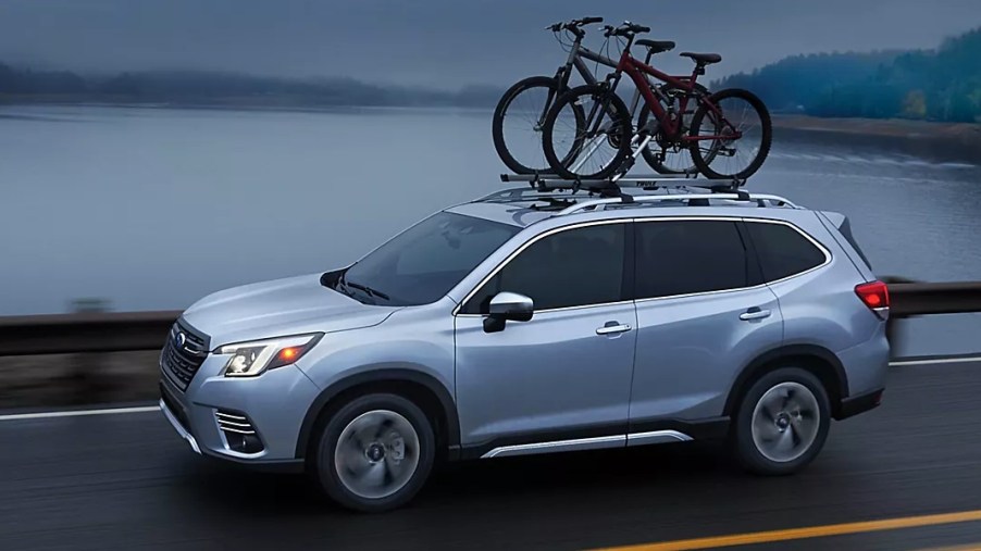 A blue 2023 Subaru Forester is driving on the road.
