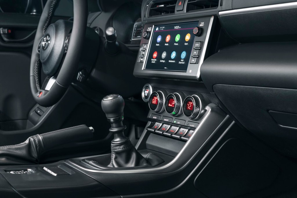 A manual transmission shift is prominent in a Toyota GR86.