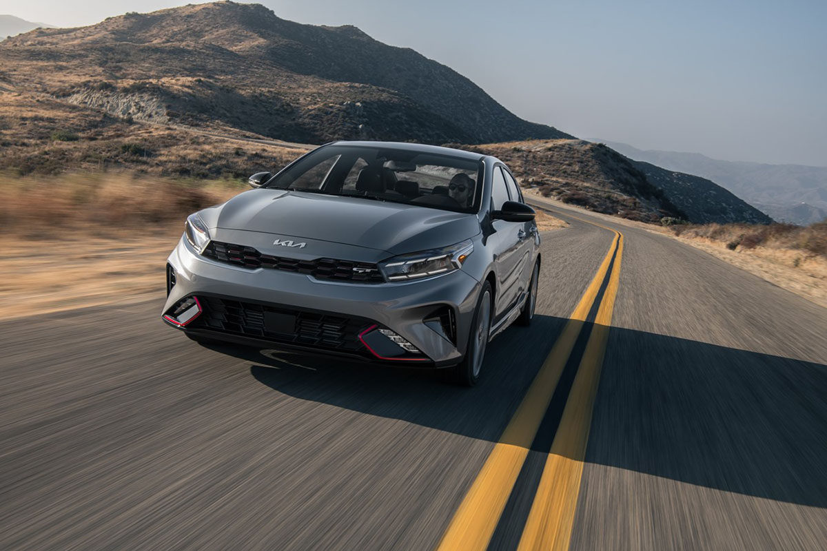 The most popular Kia car, the 2023 Forte, drives on a two-lane mountain highway