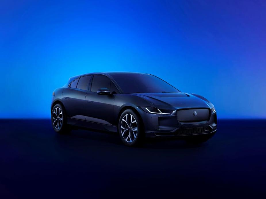 A promotional shot of a 2024 Jaguar I-Pace all-electric luxury SUV model in a blue-tinted showcase room