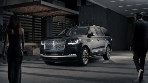 A dark black 2024 Lincoln Navigator full-size luxury SUV model demonstrating its illumination sequence