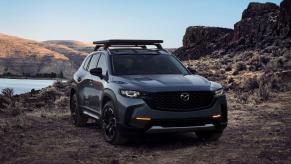 A 2024 Mazda CX-50 off-road styled compact crossover SUV in Polymetal Gray parked in the mountains