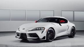 A promotion shot of a 2024 Toyota GR Supra Launch Edition sports car coupe model with a white and red paint color