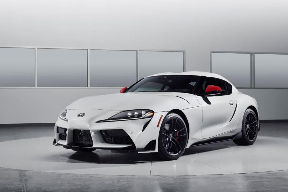 A promotion shot of a 2024 Toyota GR Supra Launch Edition sports car coupe model with a white and red paint color