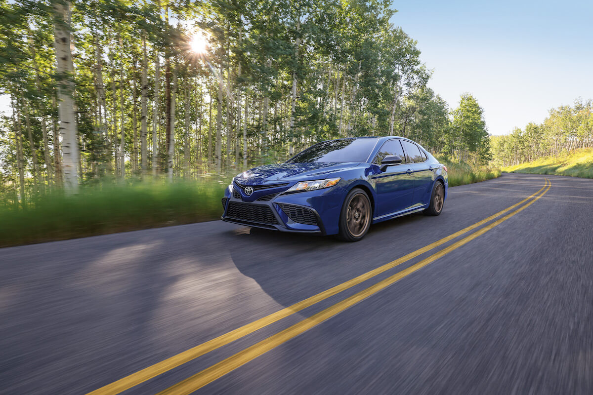 A blue 2024 Toyota Camry SE driving