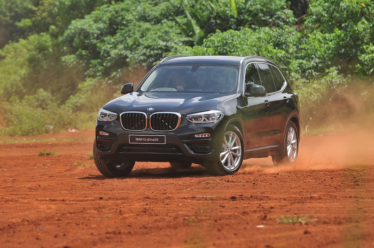 A BMW X3 luxury SUV drifts in the dirt.
