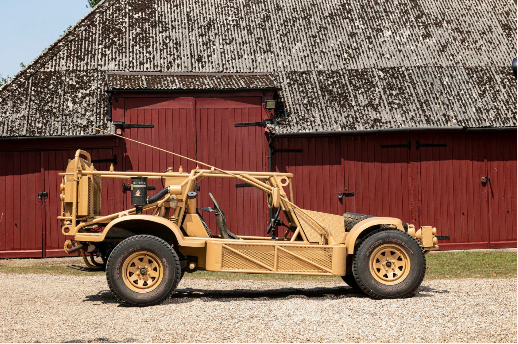British SAS Dune Buggy parked in front of a barn in profile