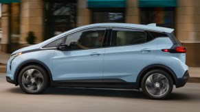 A blue 2023 Chevrolet Bolt EV is driving on the road.