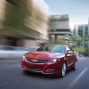 A red Chevrolet Impala blasts down a city street.