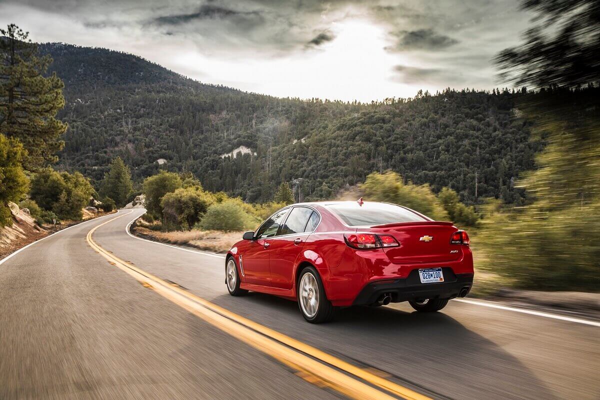 A bright-red Chevrolet SS cruises down back roads.