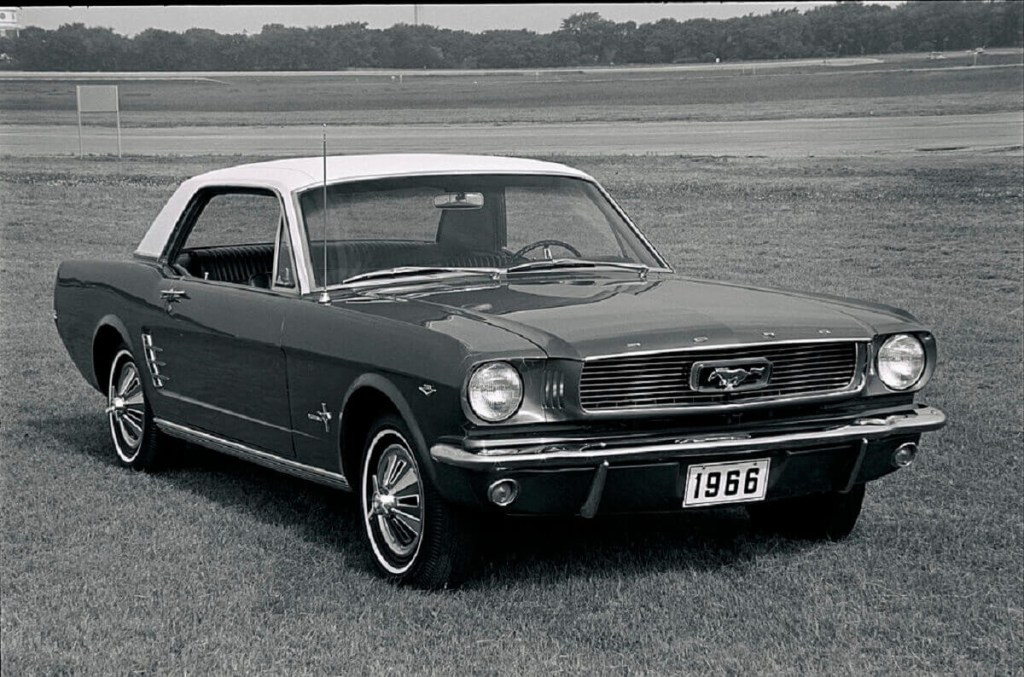 A classic Mustang, a car that benefits from non-ethanol gas, parked in a field.
