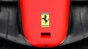 A Ferrari logo on the hood of a red and black car.