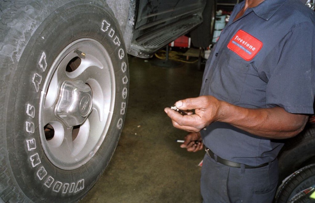 Checking the air pressure on a Firestone Wilderness AT tire on a Ford Explorer in Miami, Florida