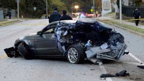 A gray S197 Ford Mustang sits in the road after the muscle car was involved in an crash.