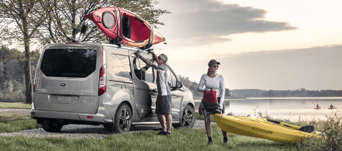 A couple transporting kayaks to a body of water using a 2023 Ford Transit Connect Titanium