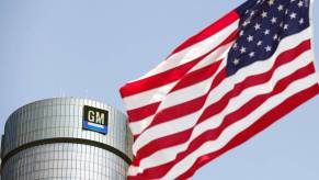 A flag waving outside of a building with a General Motors logo.
