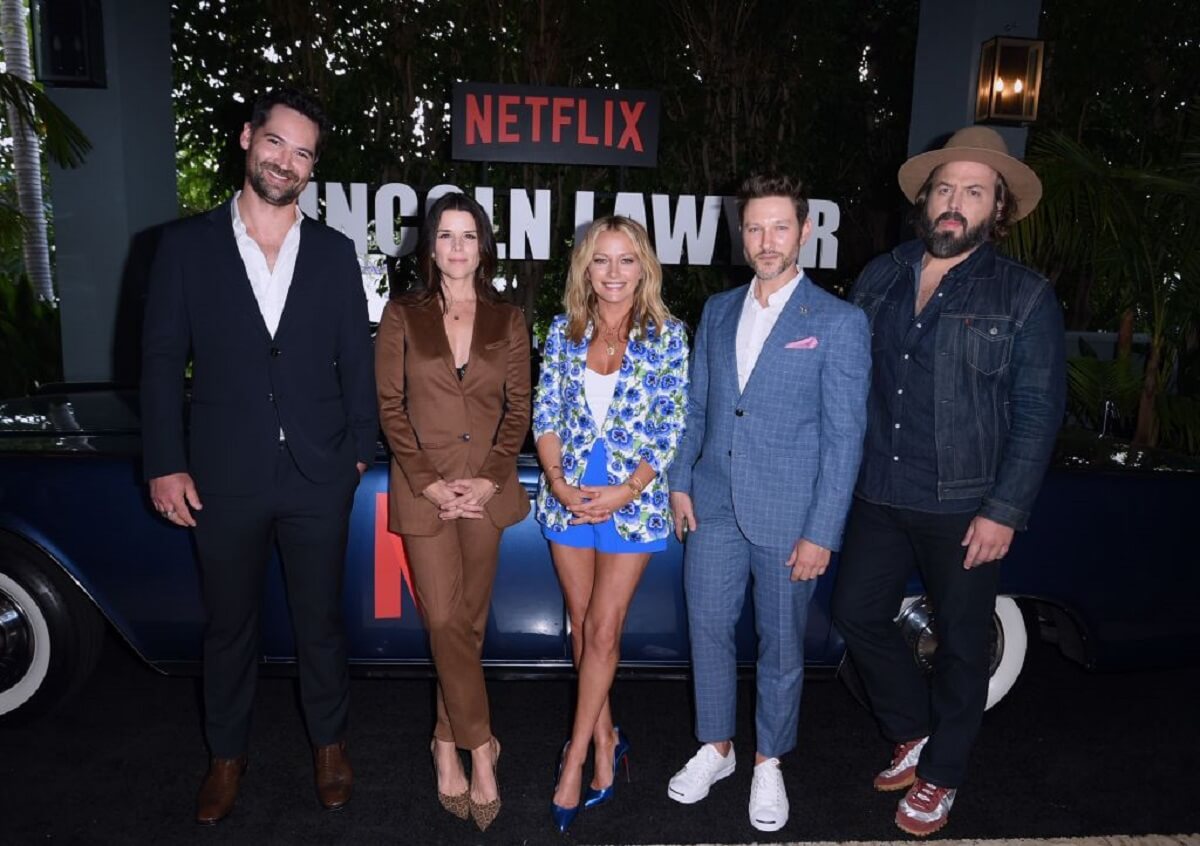 The cast of the Netflix series, "The Lincoln Lawyer" stands beside a 1963 Lincoln Continental Convertible. 