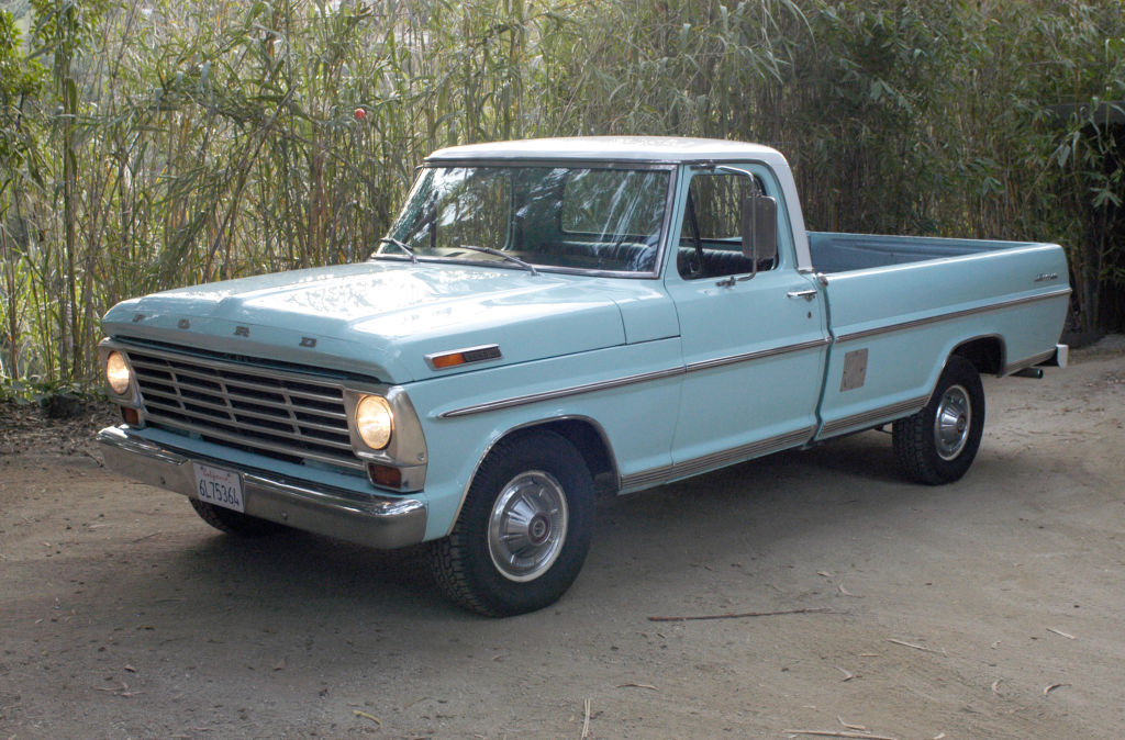 A blue 1968 F-100 truck parked on cement