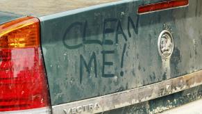 Dirty car trunk with "clean me" written on it