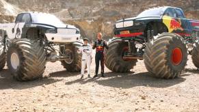 Formula 1 drivers Max Verstappen and Yuki Tsunoda stand in front of monster trucks