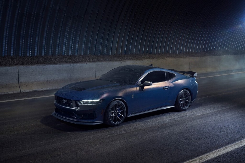 A Blue Ember Metallic Mustang Dark Horse drives through a tunnel.