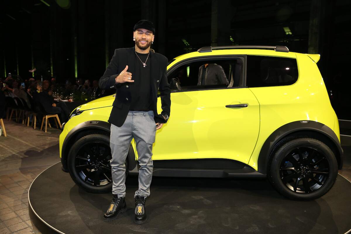 Soccer player Neymar stands next to an e.wave X electric car by e.GO