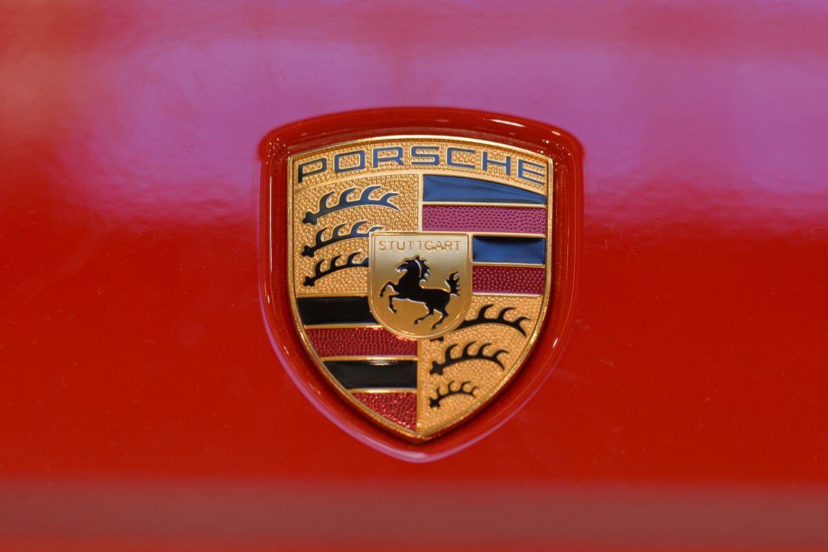 The Porsche logo featured on a red 911 Carrera 4 992 model at a Galeria Krakowska shopping mall exhibition