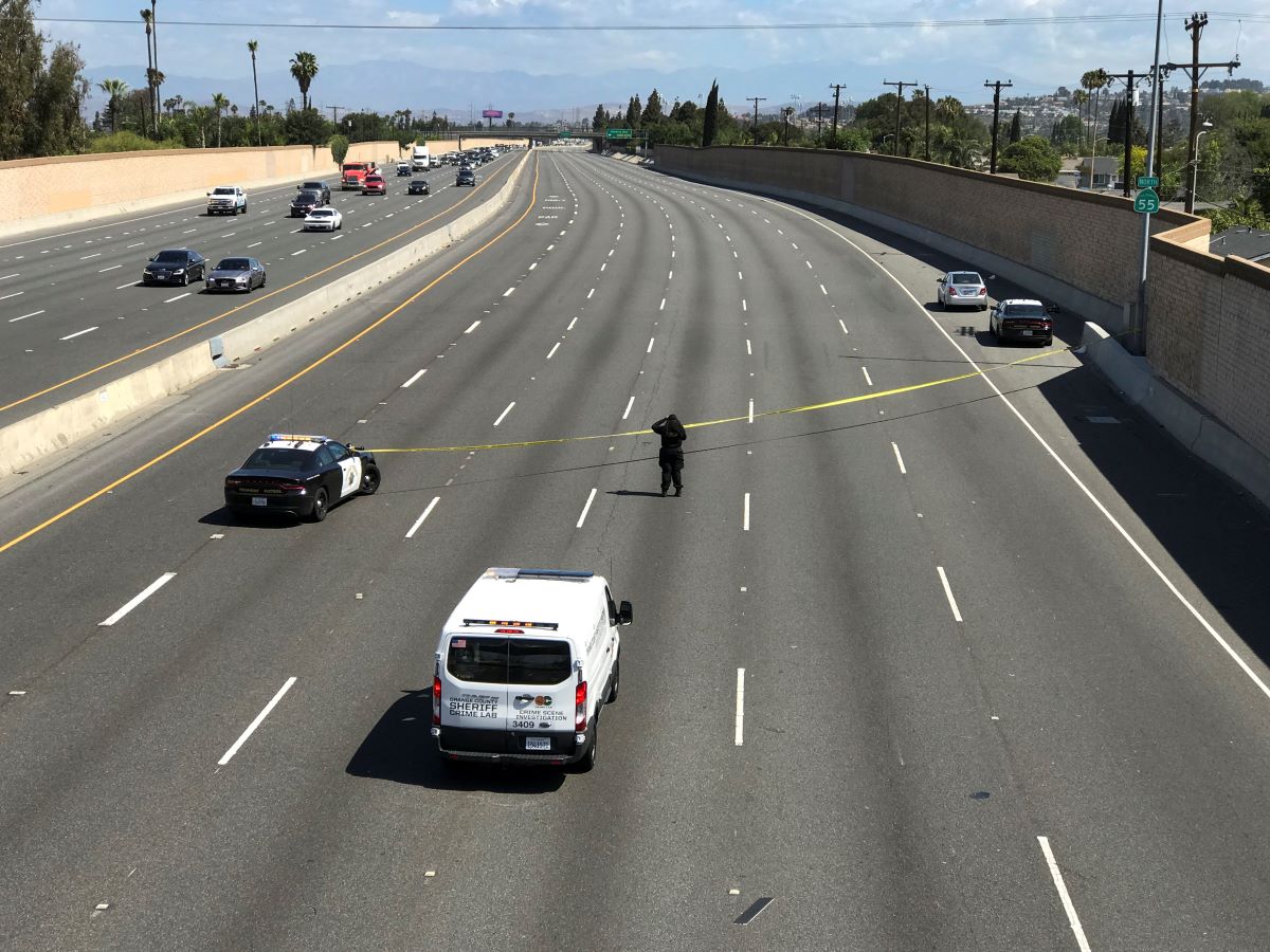 Wide shot of a highway with police cars and police tape responding to a road rage incident.