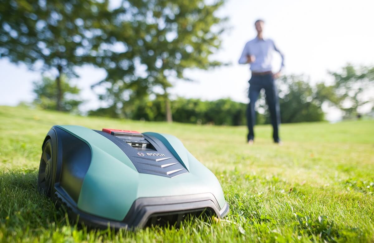 A light-green Bosch robot lawn mower mows a lawn in Germany.