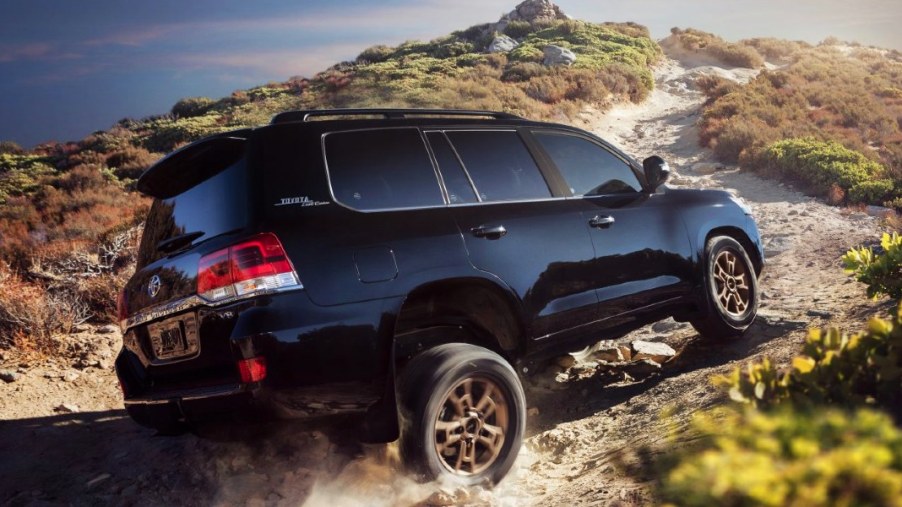 A blue 2021 Toyota Land Cruiser full-size SUV is driving off-road.