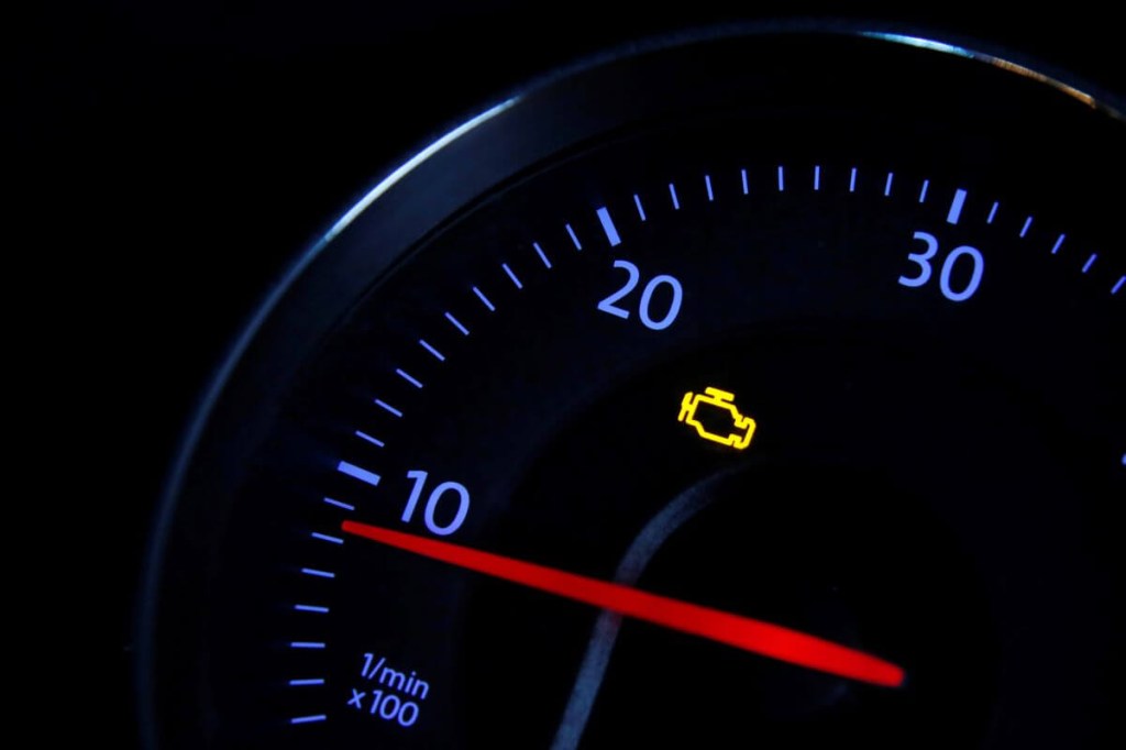 An illuminated Check Engine Light (CEL) on a Volkswagen Passat dashboard