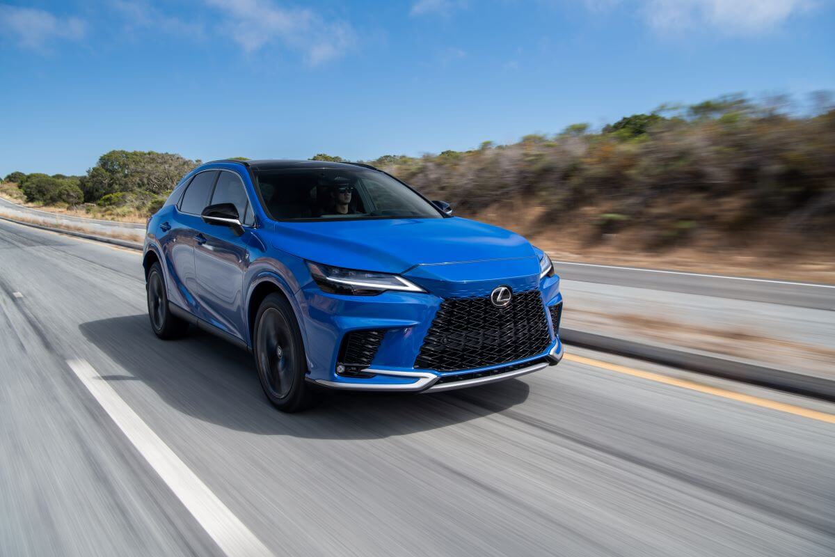 A 2023 Lexus RX 350 midsize luxury SUV model traversing down a country highway