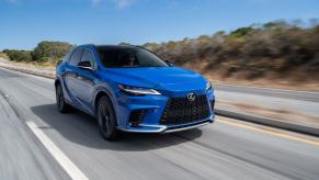 A 2023 Lexus RX 350 midsize luxury SUV model traversing down a country highway.