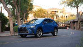A 2024 Lexus NX 350h compact luxury hybrid SUV model parked on a twisting city road
