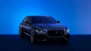 A promotion shot of a Jaguar XF Saloon midsize sports sedan in a blue-tinted room