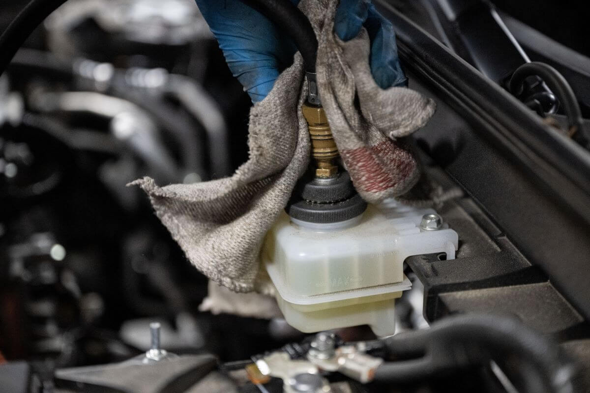 A brake fluid change performed by a garage mechanic on a Mazda MX-30 electric SUV model