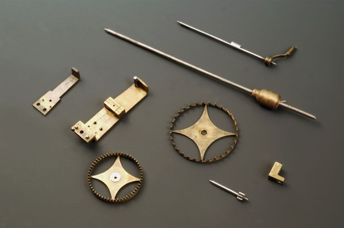 Brass wheels, pins, and other small components and parts as part of a clock from the 16th century