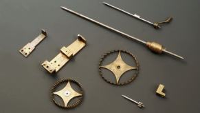 Brass wheels, pins, and other small components and parts as part of a clock from the 16th century