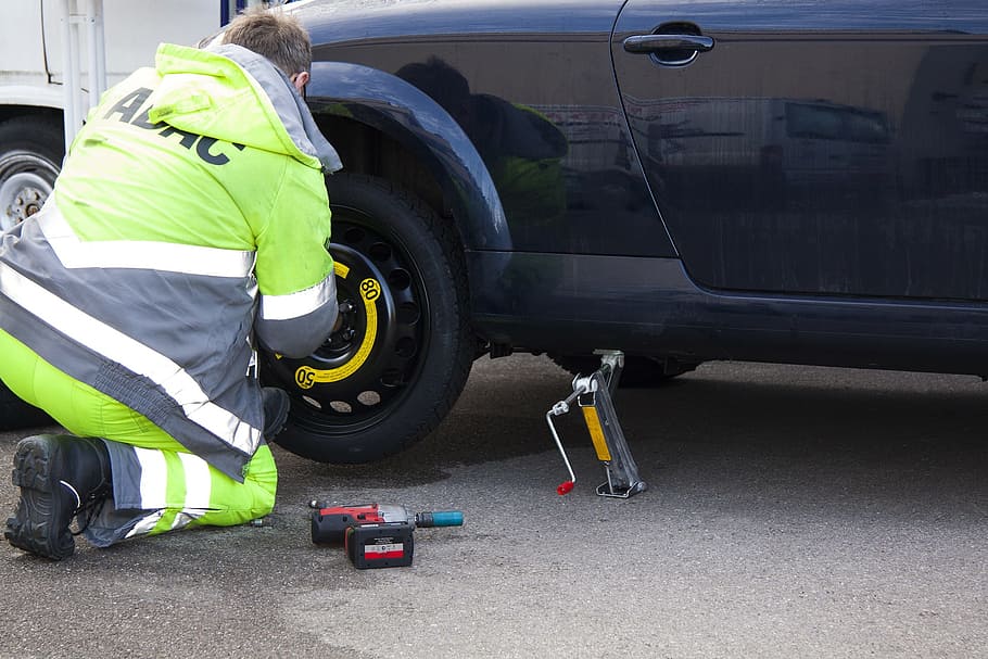 A man changing the tire of a car 