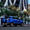 A rear shot of the trunk and spare tire on a blue 2021 Ford EcoSport subcompact SUV model parked in a city